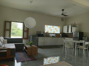 a kitchen and living room with a couch and a table at Half Way Villa in Luang Prabang