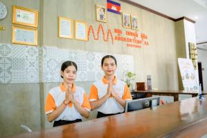 two women sitting in a room praying with their hands in front at Angkor Tempora Boutique in Siem Reap +102 photos