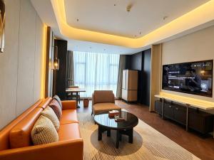 a living room with a couch and a tv at Sheraton Tengzhou in Zhaozhuang