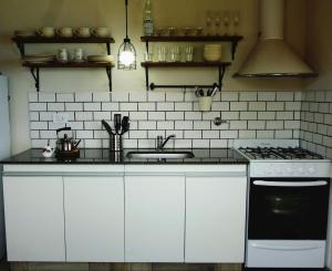 una cocina con fregadero y estufa en La Antonia Elvira, en Los Reartes