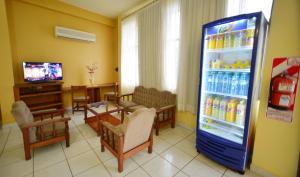 a living room with a refrigerator filled with drinks at Hotel Lilian in Puerto Iguazú