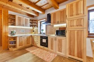 a kitchen with wooden cabinets and a stove at Drevenica Horehronka in Závadka nad Hronom