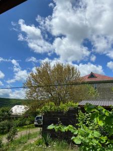 a house with a car parked in the yard at GUEST House in Qusar