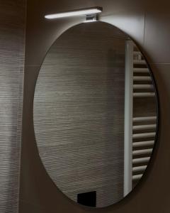 a circular mirror in a bathroom with a window at Hotel Quadrifoglio in Caraglio +35 photos