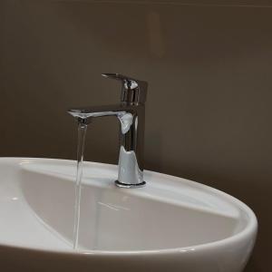 a sink with a faucet with water coming out of it at Hotel Quadrifoglio in Caraglio