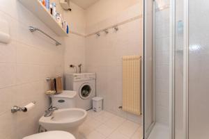 a bathroom with a toilet and a washing machine at Dolomites Soundscape - Birds River Snow Ski Bus Bike Hike in Alleghe