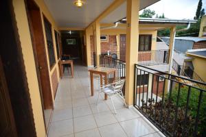 a balcony of a house with a table and a chair at Hotel Lilian in Puerto Iguazú