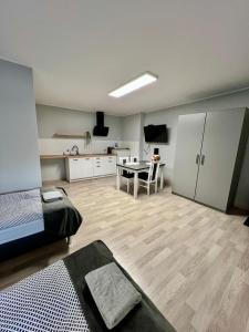 a room with a bed and a table and a kitchen at Apartamenty Adabet in Kępno