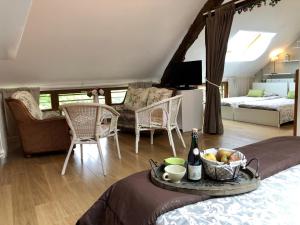 a living room with a table with a bowl of fruit on a bed at Gîte G4122 in Quincampoix