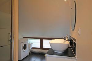 a bathroom with a sink and a washing machine at Gîte G4122 in Quincampoix