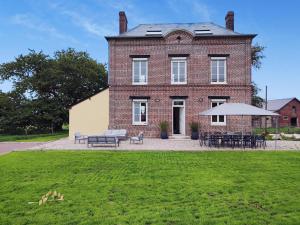 a large brick house with tables and chairs in front of it at Gîte G4144 in Saint-Pierre-de-Varengeville