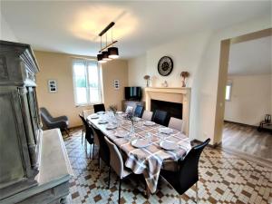 a dining room with a long table and a fireplace at Gîte G4144 in Saint-Pierre-de-Varengeville