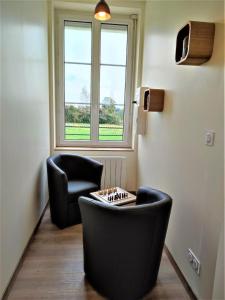 a room with two chairs and a table and a window at Gîte G4144 in Saint-Pierre-de-Varengeville