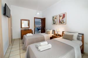 a hotel room with three beds and a television at Paxos Center in Gaios