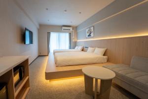 a hotel room with a bed and a couch at The ISA Hotel Tenjin Fukuoka in Fukuoka