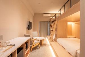a small room with a bunk bed and a desk at The ISA Hotel Tenjin Fukuoka in Fukuoka