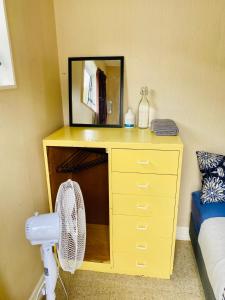 a yellow dresser with a mirror in a bedroom at Boxed Bliss on Fox in Hamilton