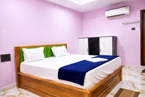 a bedroom with a large bed with purple walls at SRL Grand Residency in Tirupati