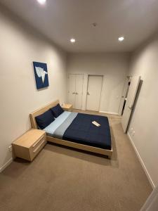 a bedroom with a large bed with a blue blanket at Viaduct Spacious 2 Bedroom Apartment in Auckland