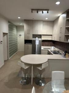a large kitchen with a table and chairs in it at Viaduct Spacious 2 Bedroom Apartment in Auckland