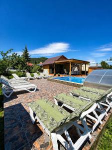 a group of lounge chairs next to a swimming pool at SpaOk & Play in Mărgăriţi
