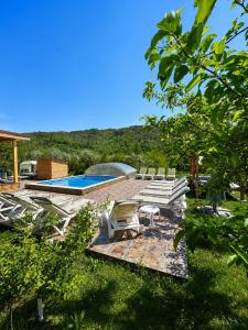 a group of lounge chairs and a swimming pool at SpaOk & Play in Mărgăriţi