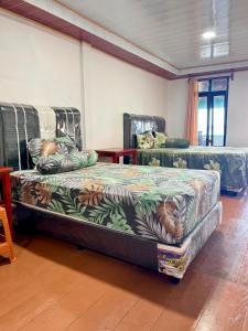 a room with two beds in a room at Marlynto Surf Camp in Hilibotodane