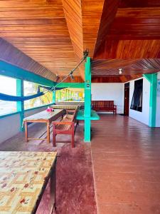 a large room with benches and ping pong tables at Marlynto Surf Camp in Hilibotodane