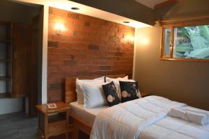 a bedroom with a bed and a brick wall at Camphor Mountain View in Lushoto