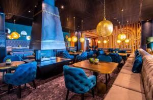 a restaurant with blue chairs and tables and a fireplace at Meiser Design Hotel in Dinkelsbühl