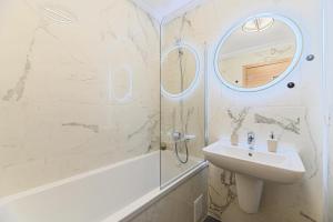 a white bathroom with a sink and a shower at MoHost Blue Moon Apartments in Braşov +14 photos