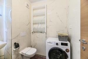 a washing machine in a bathroom with a toilet at MoHost Blue Moon Apartments in Braşov
