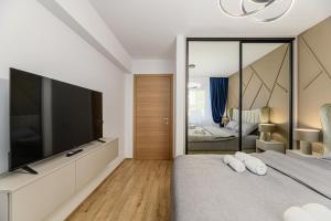 a bedroom with a large flat screen tv and a bed at MoHost Blue Moon Apartments in Braşov