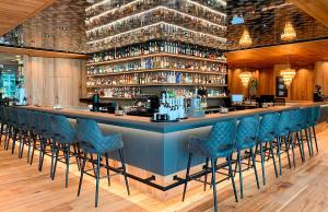 a bar with blue bar stools in a restaurant at Meiser Design Hotel in Dinkelsbühl