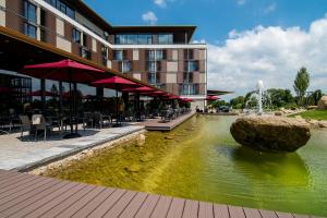 a hotel with a fountain in a pond in front of a building at Meiser Design Hotel in Dinkelsbühl