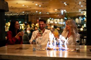 a group of people sitting at a bar with drinks at Meiser Design Hotel in Dinkelsbühl