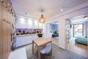 een keuken en eetkamer met een tafel en stoelen bij Apartamenty Pod Gubałówką in Zakopane
