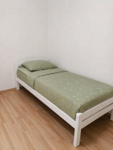a white bed in a room with a white wall at Apartman Sofija - Foča in Foča