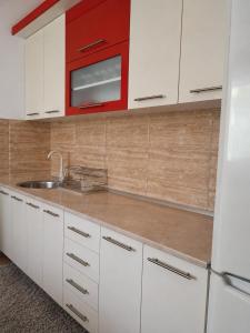 a kitchen with white cabinets and a red microwave at Apartman Sofija - Foča in Foča