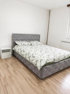 a bed in a bedroom with a wooden floor at Apartman Sofija - Foča in Foča