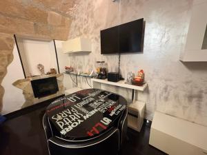ein Zimmer mit einem Stuhl und einem Fernseher an der Wand in der Unterkunft Lu bobò in Alghero