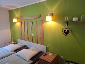 a bedroom with two beds and a green wall at Rooms Jagoda I Cozy Alpine Stay Near Bled in Blejska Dobrava