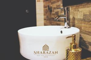 a white sink in a bathroom with a wall at Sharazan in Canicattì