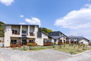 a large apartment building with a yard in front of it at Samcheok Yonghwa Silkroad Pension in Samcheok