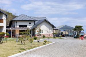 a house with a lot of trees in front of it at Samcheok Yonghwa Silkroad Pension in Samcheok