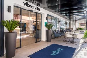 a restaurant with tables and chairs and a sign that reads vivo vivo at Hotel Vibra Vila -3SUP- New Opening 2026 in Ibiza Town