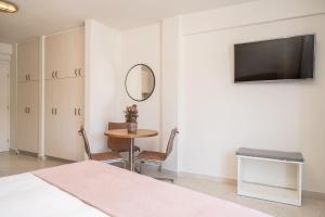 a bedroom with a bed and a table and a mirror at Argostοli Bay Apartments in Argostoli