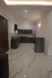 a large kitchen with marble floors and a counter top at Maktain Glance in Dehradun +38 photos