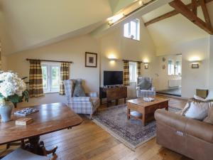 a living room with a couch and a table at Upper Pandy Farm in Welshpool