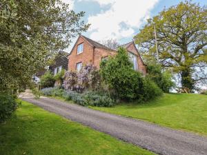 a brick house with a gravel road in front of it at Upper Pandy Farm in Welshpool
